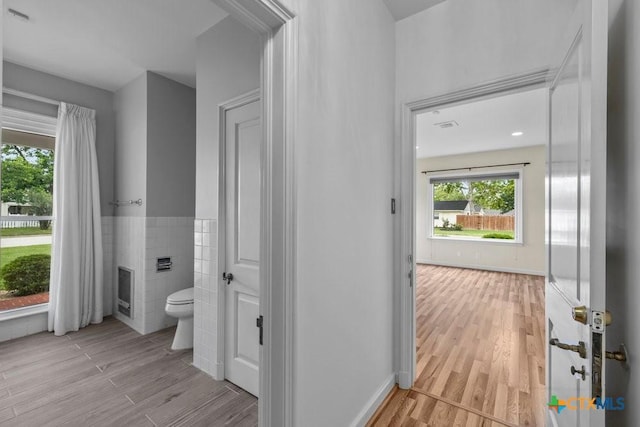 707 W Thompson Ave, Temple, TX 76501 - bathroom with toilet, tile walls, wood finished floors, and a wainscoted wall
