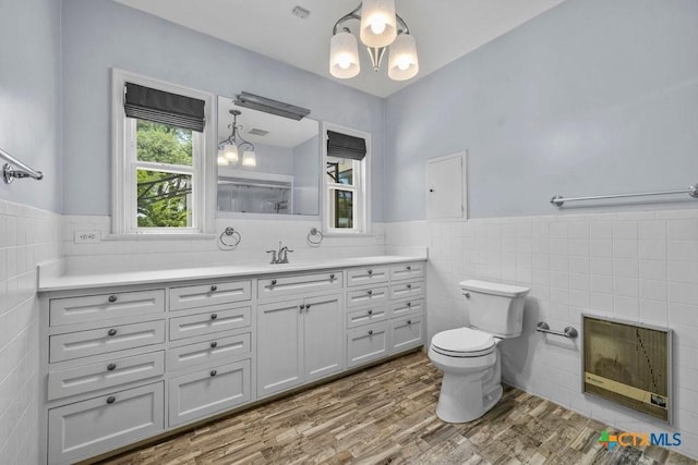 707 W Thompson Ave, Temple, TX 76501 - bathroom featuring tile walls, vanity, toilet, a wainscoted wall, and healthy amount of natural light