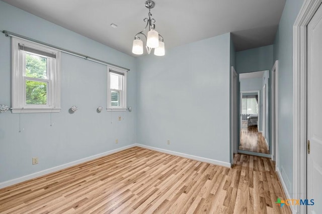 707 W Thompson Ave, Temple, TX 76501 - empty room featuring light wood finished floors, baseboards, and a chandelier