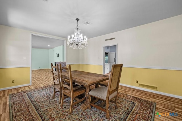 707 W Thompson Ave, Temple, TX 76501 - dining area with wood finished floors, a chandelier, and baseboards