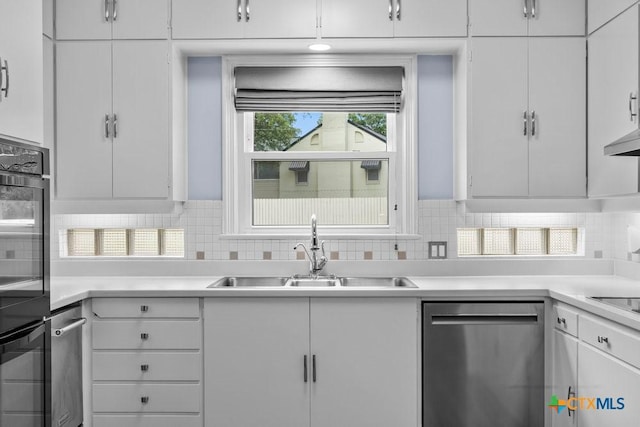 707 W Thompson Ave, Temple, TX 76501 - kitchen featuring dishwasher, a sink, backsplash, and white cabinets
