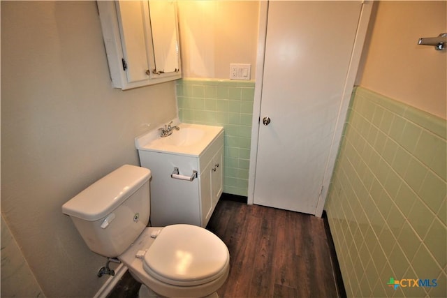 bathroom featuring hardwood / wood-style floors, vanity, tile walls, and toilet