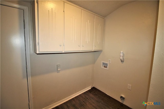 washroom with washer hookup, dark hardwood / wood-style flooring, and cabinets