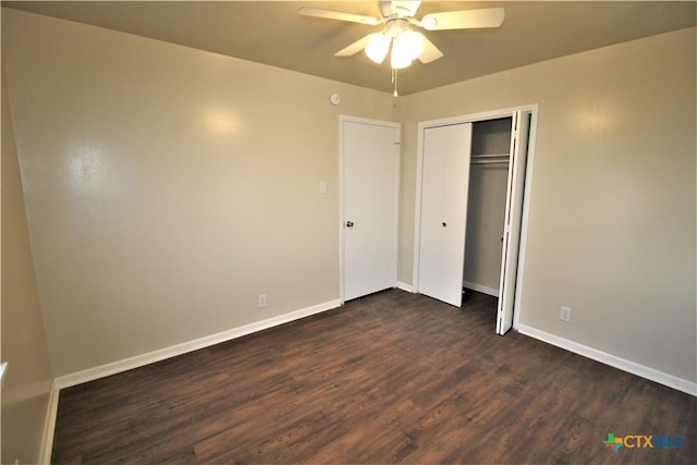 unfurnished bedroom with ceiling fan, dark wood-type flooring, and a closet