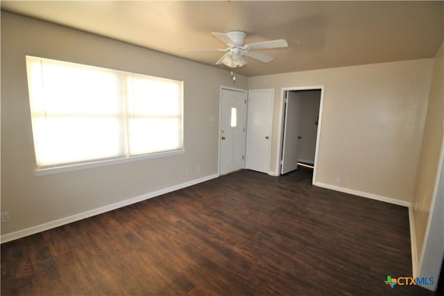 empty room with ceiling fan and dark hardwood / wood-style flooring