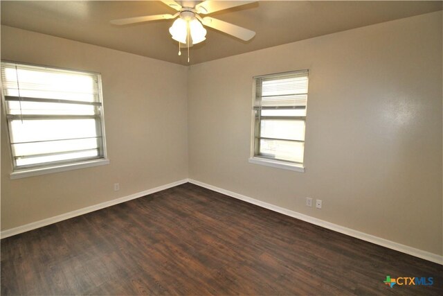 spare room with ceiling fan, plenty of natural light, and dark hardwood / wood-style floors