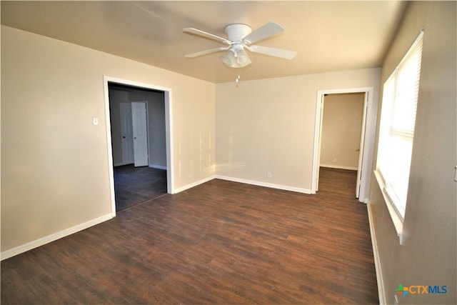 empty room featuring ceiling fan and dark wood-type flooring