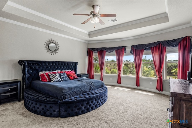 bedroom with ceiling fan, a raised ceiling, light colored carpet, and crown molding