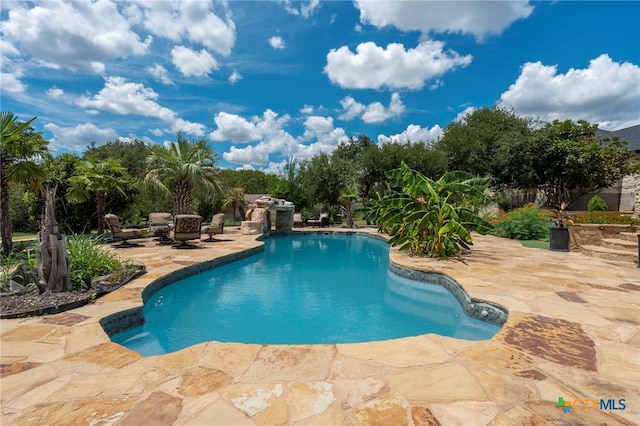 view of swimming pool with a fire pit and a patio area