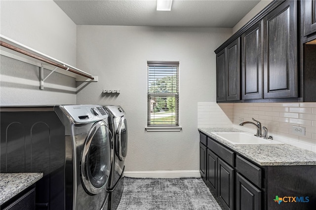 washroom featuring a textured ceiling, cabinets, independent washer and dryer, and sink