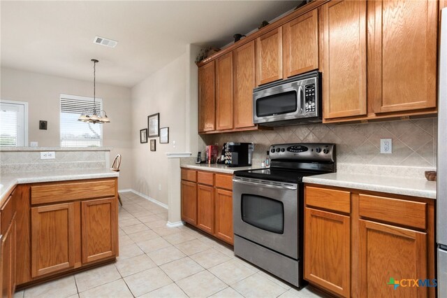 kitchen featuring stainless steel appliances, backsplash, and a chandelier