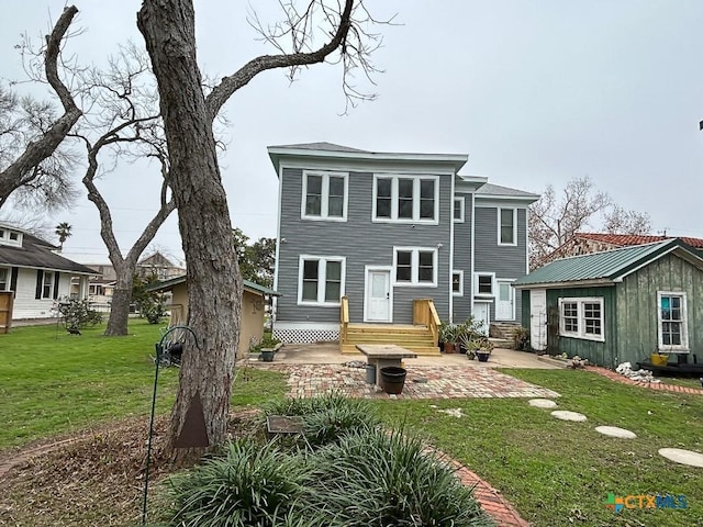 rear view of property with an outbuilding, a yard, and a patio area