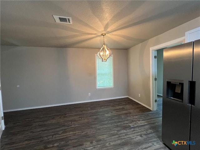 908 S 22nd St, Temple, TX 76501 - spare room featuring a chandelier, dark wood-type flooring, baseboards, and a textured ceiling