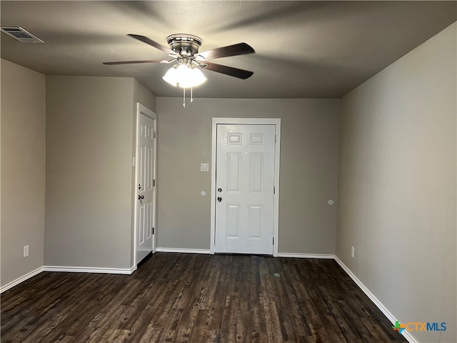 spare room with ceiling fan, a textured ceiling, and dark hardwood / wood-style flooring