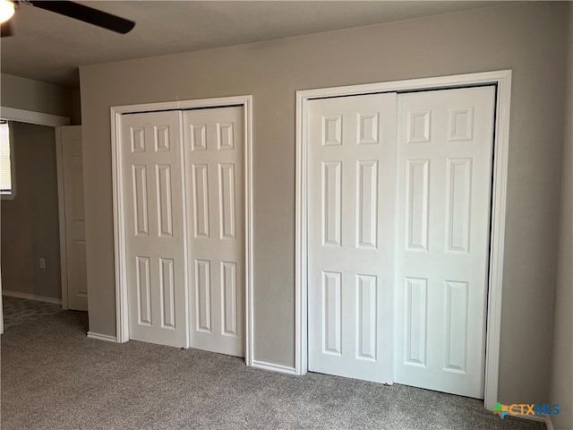 unfurnished bedroom featuring multiple closets and carpet