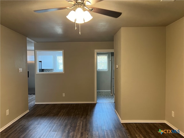 spare room featuring dark hardwood / wood-style flooring and ceiling fan