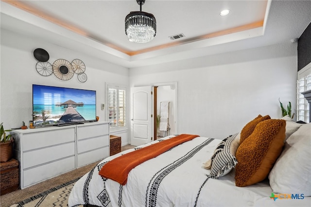 carpeted bedroom with a tray ceiling