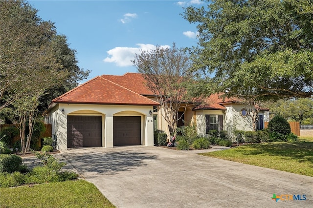 mediterranean / spanish house with a front lawn and a garage