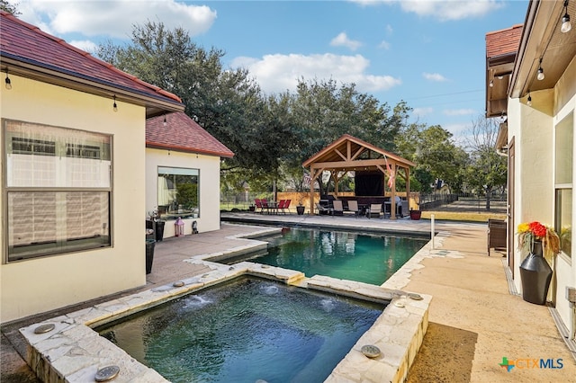 view of pool featuring a patio, a gazebo, and an in ground hot tub