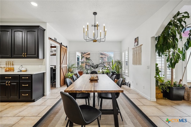 dining space with a chandelier, a barn door, light tile patterned flooring, and a textured ceiling