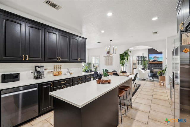 kitchen with hanging light fixtures, a textured ceiling, light tile patterned floors, and a kitchen island