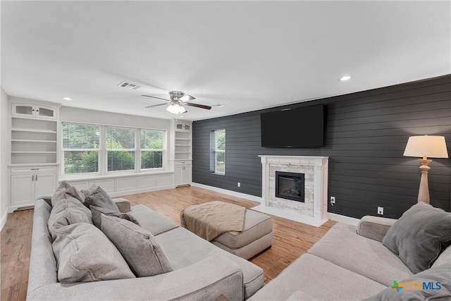 7031 Steinbeck Bend Dr, Waco, TX 76708 - living room with built in shelves, a ceiling fan, light wood finished floors, a high end fireplace, and recessed lighting