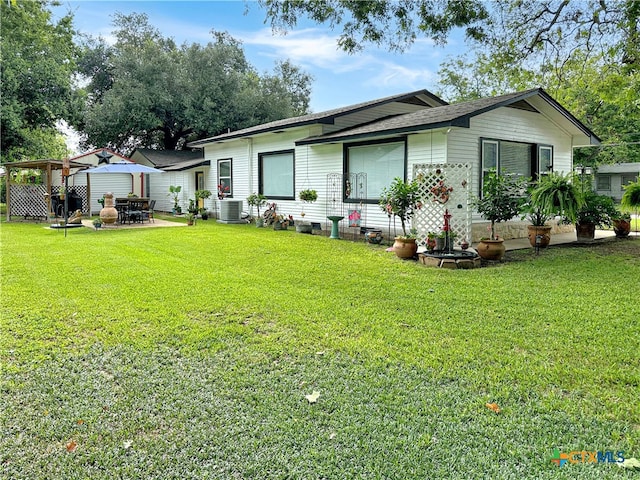 back of house featuring an outdoor fire pit, a lawn, cooling unit, and a patio area