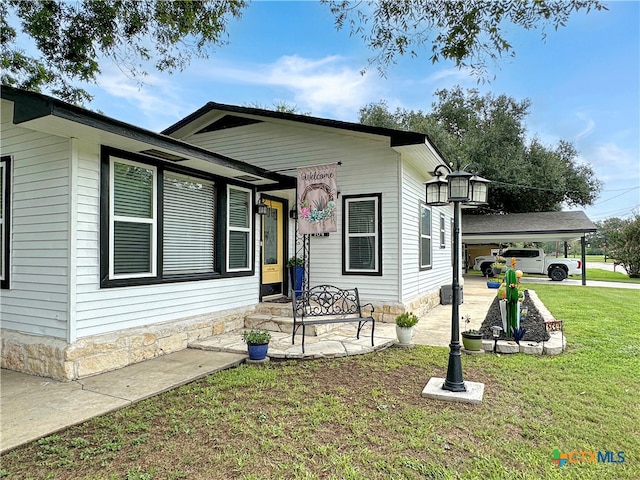 view of front of home featuring a front lawn and a carport