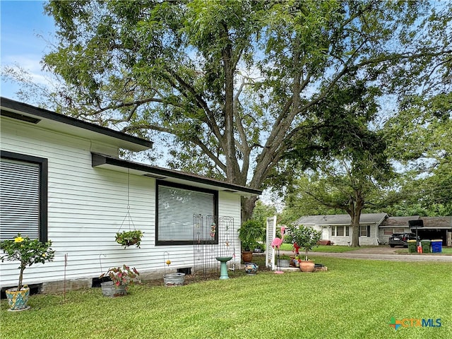 view of side of property featuring a yard and a patio area