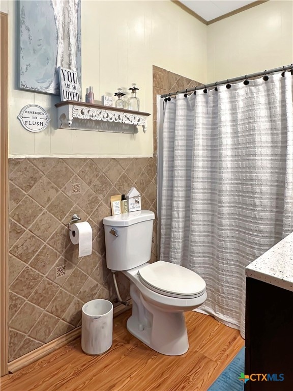 bathroom with toilet, tile walls, and hardwood / wood-style flooring