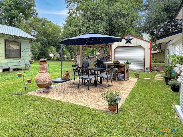 view of yard with an outbuilding, a patio, and a garage