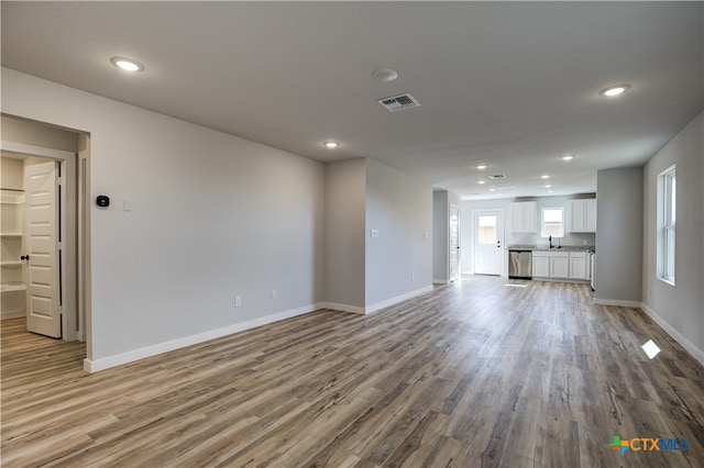 unfurnished living room featuring sink and wood-type flooring