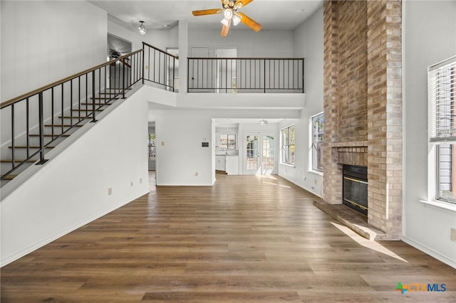 unfurnished living room featuring a fireplace, a wealth of natural light, and wood-type flooring