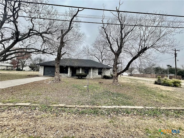 view of front of property with concrete driveway, a front lawn, and an attached garage