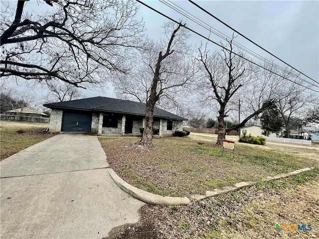 view of front of home with an attached garage, concrete driveway, and roof with shingles