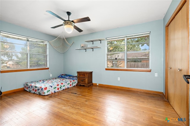 bedroom featuring ceiling fan, a closet, and light wood-type flooring