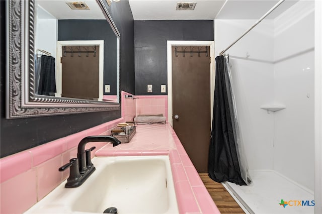 bathroom featuring hardwood / wood-style flooring, vanity, and curtained shower