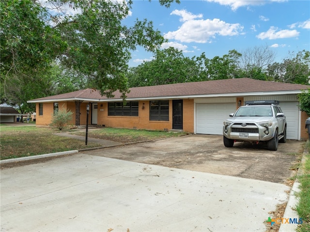 single story home featuring a garage and a front yard