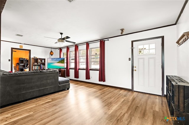 living room featuring light hardwood / wood-style floors, ceiling fan, and crown molding