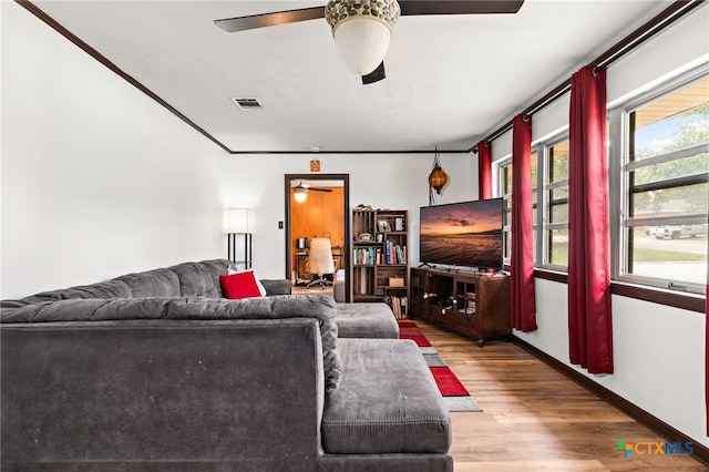 living room featuring ceiling fan, wood-type flooring, and ornamental molding