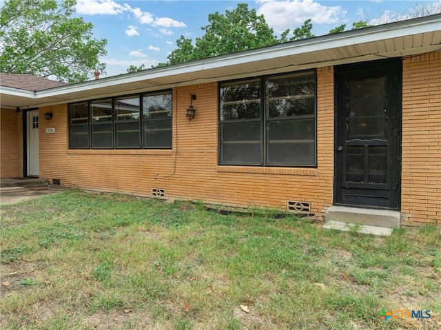 entrance to property with a lawn