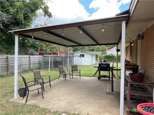 view of patio with a storage unit and a grill