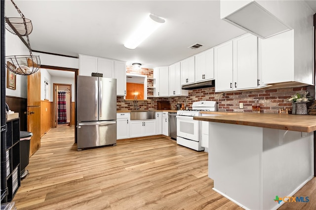 kitchen featuring butcher block counters, white cabinetry, sink, appliances with stainless steel finishes, and light wood-type flooring