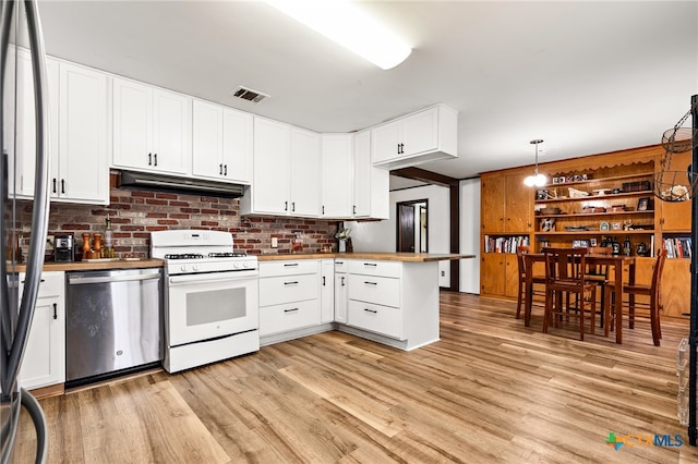 kitchen with pendant lighting, white cabinets, stainless steel dishwasher, white gas stove, and light hardwood / wood-style flooring