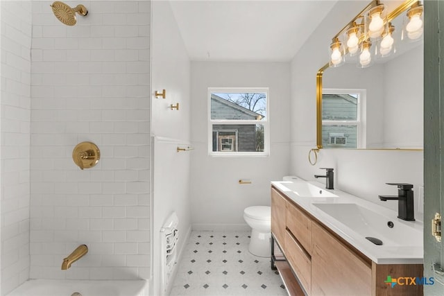 full bathroom featuring tiled shower / bath, vanity, and toilet