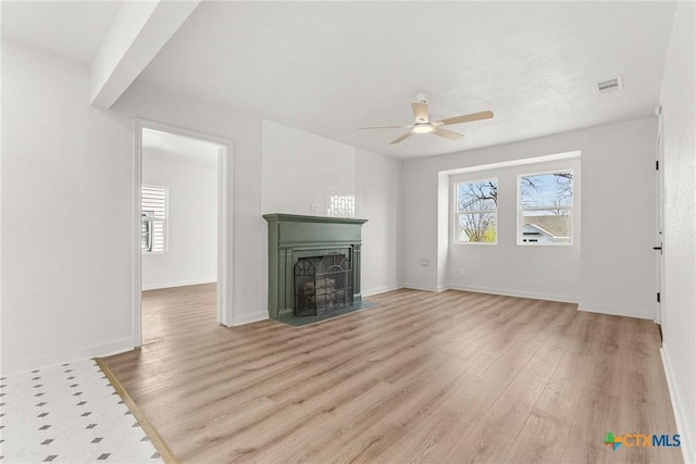 unfurnished living room with ceiling fan, plenty of natural light, and light hardwood / wood-style flooring