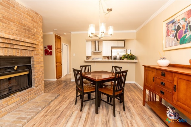 dining room with a fireplace, light hardwood / wood-style flooring, and crown molding