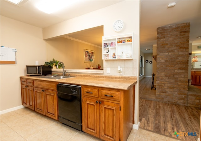 kitchen with sink, light hardwood / wood-style flooring, crown molding, decorative columns, and black dishwasher