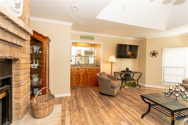 living room with ornamental molding, sink, hardwood / wood-style floors, and a healthy amount of sunlight