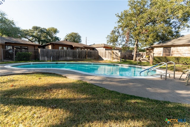 view of swimming pool featuring a patio and a yard